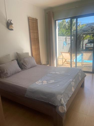 a large bed in a room with a large window at Villa Coco in Trou aux Biches