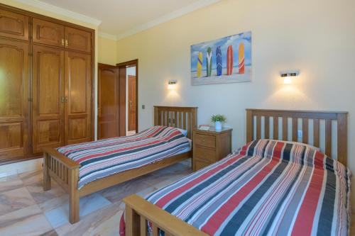 sypialnia z dwoma łóżkami i obrazem na ścianie w obiekcie Villa Loretta w Puerto del Carmen