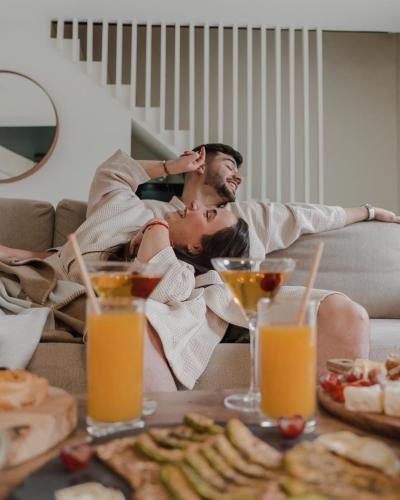 a man laying on a couch with a table of food at Serenity Villa - Détente & Chill in Cormeilles-en-Parisis