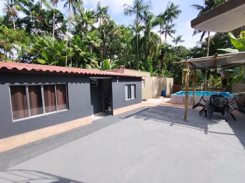 a house with a patio and a swimming pool at Suítes em Cananéia SP in Cananéia