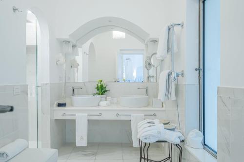 a white bathroom with two sinks and a mirror at Hotel Palazzo Murat in Positano