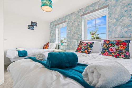 a bedroom with two beds with pillows on them at Black Friday Deal - Stunning 2BR House with Garden, Netflix Walk 30min to Alton Tower in Stoke on Trent