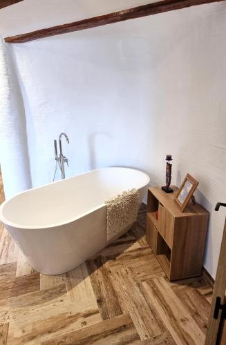 a white bath tub in a bathroom with wood floors at La Petite Chaouen de Galera in Galera