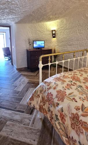a bedroom with a bed and a tv on a wall at La Petite Chaouen de Galera in Galera