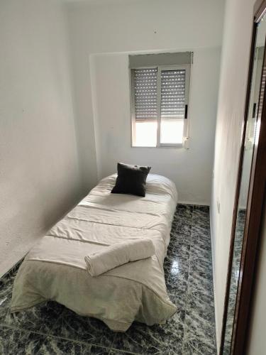 a bed in a room with a pillow on it at Calle platano37 in Valencia