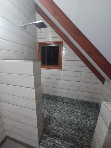 a bathroom with a window and a television at La Banane Rouge Self Catering in La Digue