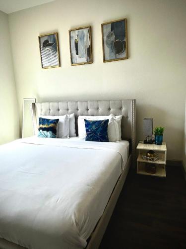 a bedroom with a large white bed with four pictures on the wall at Distinct Houston Luxury Downtown in Houston