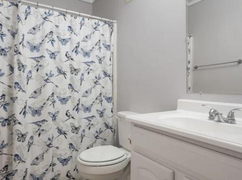a bathroom with a toilet and a shower curtain at Amenities and beach access! in Hilton Head Island
