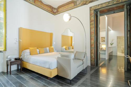 a bedroom with a large bed and a chair at Hotel Palazzo Murat in Positano