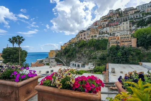 a view of positano from a balcony with flowers at Hotel Palazzo Murat in Positano