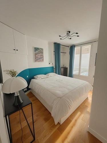 - une chambre avec un grand lit et une table avec une lampe dans l'établissement Flexliving - 1 bedroom - Hauteville, à Paris