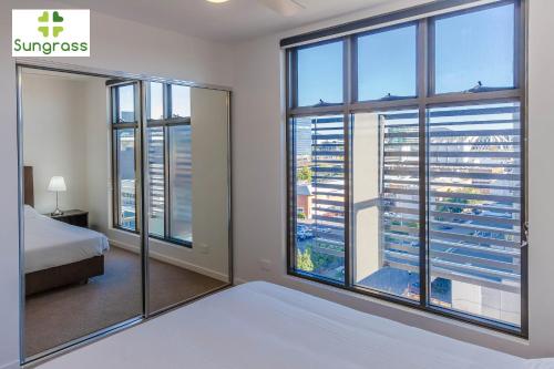 a bedroom with a bed and a large window at Fleet Lane Apartments in Brisbane
