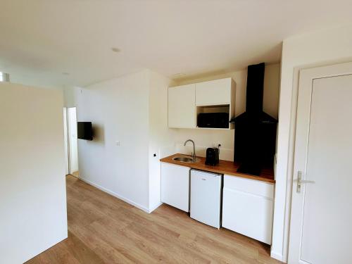 une cuisine avec des armoires blanches et un plancher en bois dans l'établissement Julada Appartement, à Bègles
