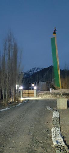 a kite flying over a road with a snow covered mountain at Devaranya Homestay in Leh