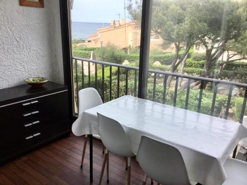 Cette chambre dispose d'un balcon avec une table et des chaises blanches. dans l'établissement Studio vue mer, à Sausset-les-Pins