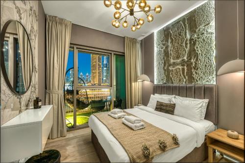 a bedroom with a large bed and a large window at Dubai Mall Connection - Burj Views - Turf Balcony in Dubai