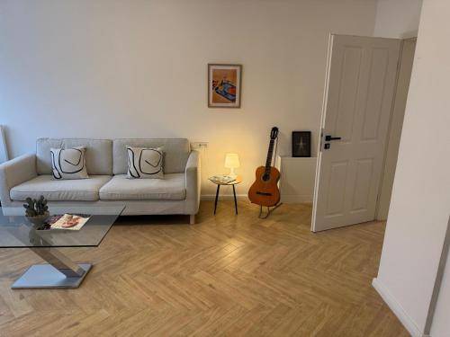 a living room with a couch and a guitar at Apartment Lutherbaum in Worms