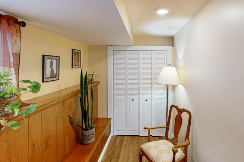 a hallway with a chair and a plant and a door at Hidden Haven in Bath