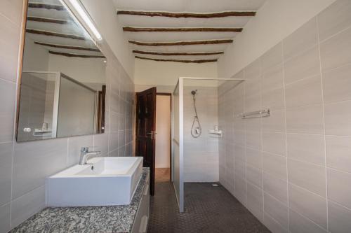 une salle de bain avec un lavabo blanc et un miroir dans l'établissement Cozy house 140 sqm with pool, à Diani Beach
