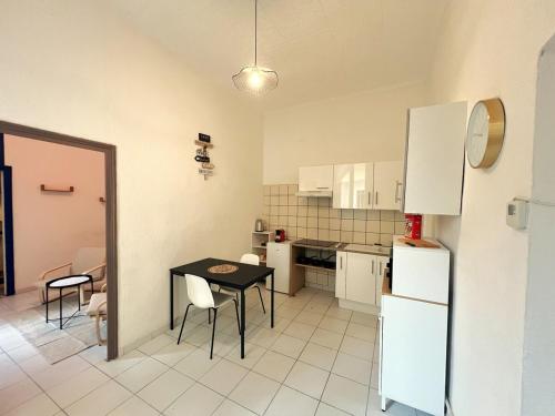 une petite cuisine avec une table et un réfrigérateur dans l'établissement Charmant T2 proche centre Nîmes, à Nîmes