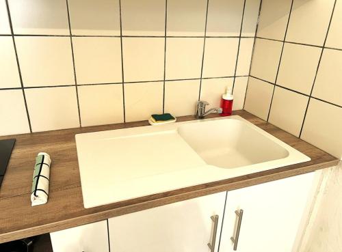 La salle de bains est pourvue d'un lavabo blanc et de carrelage blanc. dans l'établissement Charmant T2 proche centre Nîmes, à Nîmes