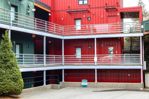 a red building with balconies on the side of it at Tofino Waterfront Condo in Tofino