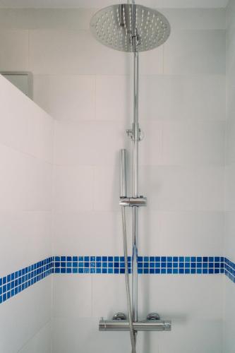 a shower in a bathroom with blue tiles at Casa Bianca 2 in Teulada