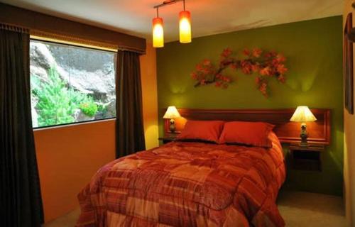 a bedroom with a bed with red pillows and a window at Posadas del Castillo del Titicaca in Vencalla