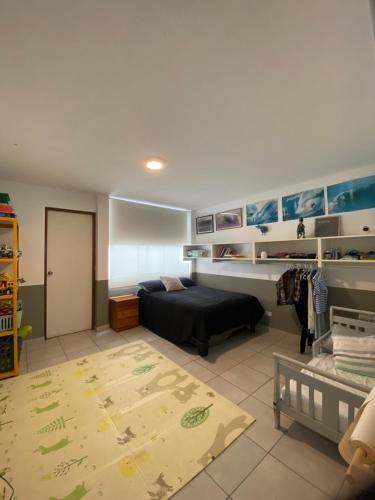 a bedroom with a bed and a rug in a room at Watermanhouse, Punta Hermosa in Lima