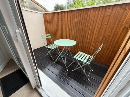 un patio avec une table et des chaises sur une terrasse dans l'établissement Julada Appartement, à Bègles