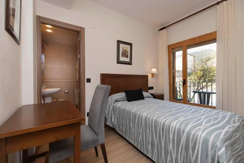 a bedroom with a bed and a desk and a table at Hotel Cinca in Escalona
