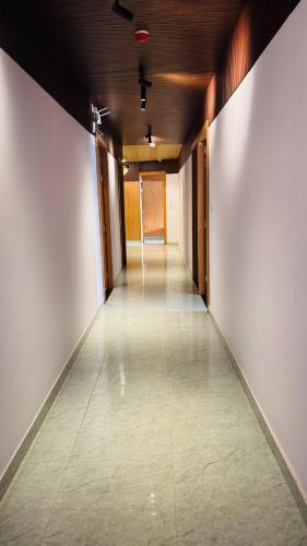 an empty hallway with white walls and a tile floor at The royal hotel in Bareilly