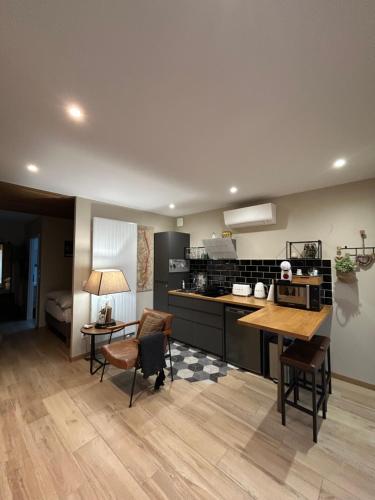 une cuisine avec un comptoir, une table et des chaises dans l'établissement Chez Marlène, à Comblanchien