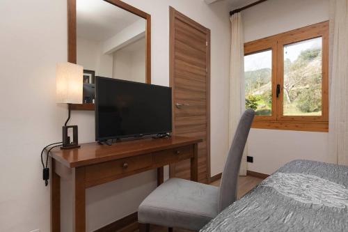a bedroom with a desk with a television and a chair at Hotel Cinca in Escalona