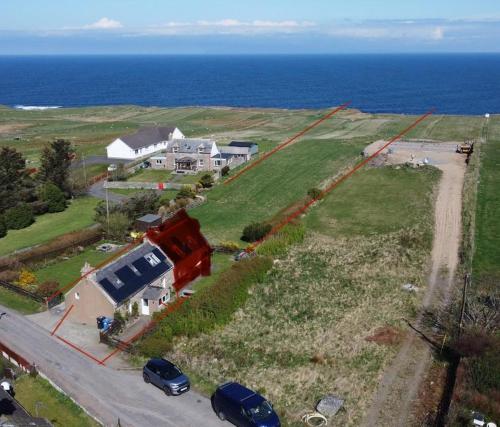 an aerial view of a house and the ocean at Traditional 2 bed croft in Portskerra
