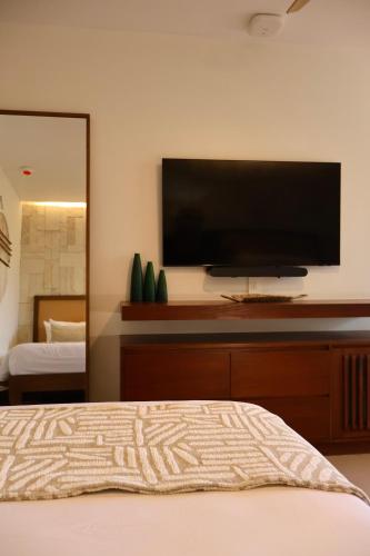 a bedroom with a flat screen tv on the wall at Hotel Mundo Maya Palenque in Palenque