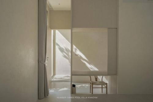 a room with a mirror and a chair in a room at Number Three Pool Villa Khaoyai in Ban Tha Maprang