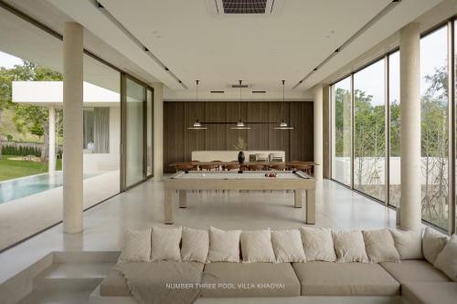a living room with a large couch and a pool table at Number Three Pool Villa Khaoyai in Ban Tha Maprang