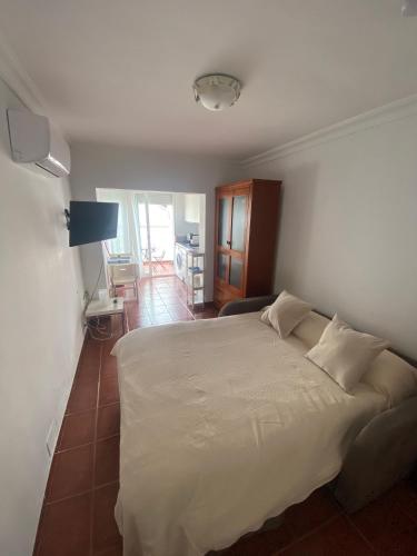 ein Schlafzimmer mit einem weißen Bett in einem Zimmer in der Unterkunft Casa Ana Maro in Maro