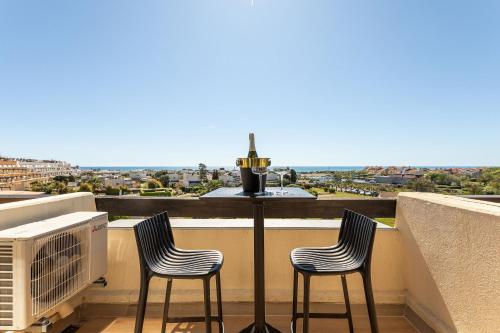 trois chaises assises sur un balcon avec vue sur la ville dans l'établissement Village Naturiste R4N - GoldenKiss Port Nature, au Cap d'Agde