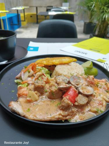 a plate of food with a pizza on a table at Hostel Joy Calle 85 in Bogotá