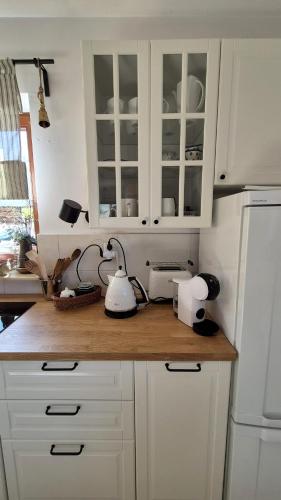 a kitchen counter with white cabinets and a white refrigerator at Józefówka - dom z 4 sypialniami, z balią ,dużym tarasem i pięknym widokiem na Wysową in Wysowa-Zdrój