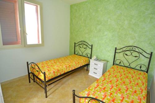 a bedroom with two beds and a dresser and a window at Ginestra ONE 30m Front SEA by Salento Prime in Torre Vado