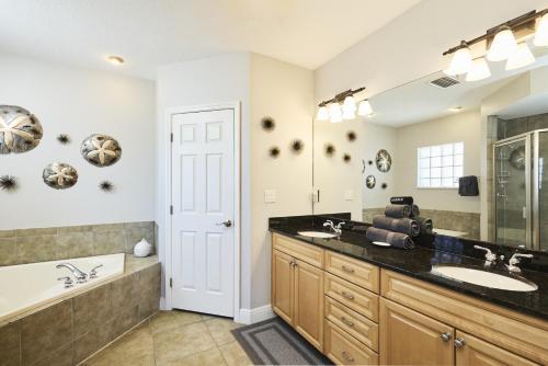 a bathroom with a sink and a tub and a mirror at Mojito Haze beach retreat in St Pete Beach