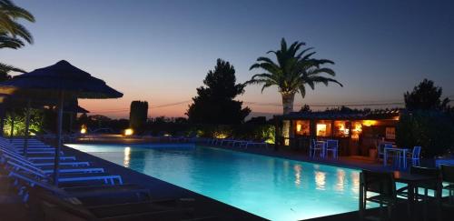 une piscine avec des chaises longues et un complexe hôtelier dans l'établissement Résidence Le Padro - Calvi - F2 45m2 climatisé, à Calvi