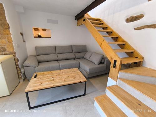 ein Wohnzimmer mit einer Couch und einer Treppe in der Unterkunft La Casita de la Parra in Ronda