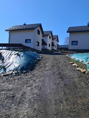 a dirt road in front of some buildings at Domki w Bieszczadach Kuźmina in Kuźmina