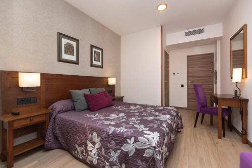 a bedroom with a bed and a desk and a table at Hotel Cinca in Escalona