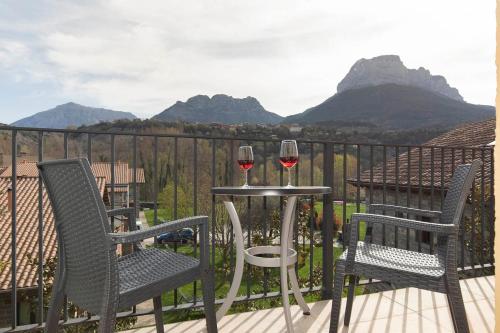 two glasses of wine sitting on a table on a balcony at Hotel Cinca in Escalona