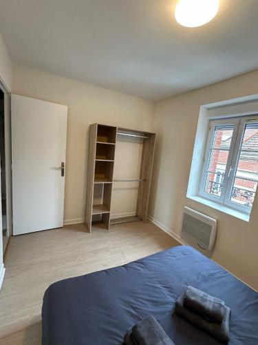 une chambre avec un lit bleu et une fenêtre dans l'établissement Le chal'heureux, Appartement chic au cœur d'Épernay, à Épernay